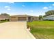 Attractive home features a well-kept lawn, decorative palm, and a spacious driveway leading to an oversized garage at 9958 Sw 59Th Cir, Ocala, FL 34476