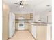 Bright kitchen featuring wooden cabinets, white appliances, and a view to the living area at 9958 Sw 59Th Cir, Ocala, FL 34476