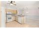 Bright kitchen with white appliances and wooden cabinets, flowing into the expansive living area at 9958 Sw 59Th Cir, Ocala, FL 34476