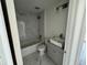 Bathroom with a marble-tiled shower/tub combination, toilet, sink, and vanity with a gray cabinet at 1057 Nw 68Th Pl, Ocala, FL 34474