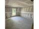 Bedroom featuring unfinished drywall walls, a window overlooking the green yard, and smooth concrete floor at 1057 Nw 68Th Pl, Ocala, FL 34474