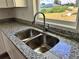 Kitchen featuring a stainless steel sink, granite countertops, and a large window overlooking the yard at 1057 Nw 68Th Pl, Ocala, FL 34474