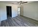 Main bedroom with wood-look flooring, ceiling fan, and access to the bathroom at 1057 Nw 68Th Pl, Ocala, FL 34474