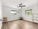 Bright bedroom featuring wood-look flooring, a modern ceiling fan, and two windows at 11245 Sw 63Rd Terrace Rd, Ocala, FL 34476