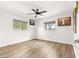 Spacious bedroom with wood-look flooring, modern ceiling fan, and several windows at 11245 Sw 63Rd Terrace Rd, Ocala, FL 34476