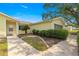 The side exterior of a yellow home with manicured landscaping along the sidewalk and front facade at 11245 Sw 63Rd Terrace Rd, Ocala, FL 34476