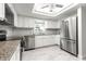 Well-lit kitchen showcasing granite counters, white cabinets and modern stainless-steel appliances including a refrigerator at 11245 Sw 63Rd Terrace Rd, Ocala, FL 34476