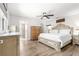 Bright main bedroom featuring light wood floors, a ceiling fan and an ensuite bathroom for added privacy at 11245 Sw 63Rd Terrace Rd, Ocala, FL 34476
