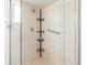 Modern shower featuring tile walls, glass doors, and a corner shelving unit, perfect for storage at 11245 Sw 63Rd Terrace Rd, Ocala, FL 34476