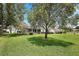 Expansive backyard featuring a well-maintained lawn, mature trees, and partial view of the house at 13786 Se 88Th Ct, Summerfield, FL 34491