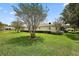 Spacious backyard showcasing a well-kept lawn, mature trees, and a view of the home's exterior at 13786 Se 88Th Ct, Summerfield, FL 34491