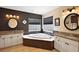 Bathroom with a large soaking tub, dual sinks, and granite countertops at 13786 Se 88Th Ct, Summerfield, FL 34491