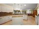 Spacious kitchen featuring white cabinets, granite countertops, a central island, and an open layout at 13786 Se 88Th Ct, Summerfield, FL 34491