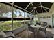 Charming screened patio with comfortable seating, ceiling fan, and views of the landscaped backyard at 13786 Se 88Th Ct, Summerfield, FL 34491