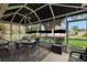 Inviting screened patio with comfortable seating, a ceiling fan, and scenic views of the green yard at 13786 Se 88Th Ct, Summerfield, FL 34491