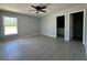 Bedroom features a ceiling fan, gray flooring and view of bathroom at 15419 Sw 65Th Terrace Rd, Ocala, FL 34473
