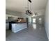 Spacious open-concept with modern light fixture and gray tile flooring at 15419 Sw 65Th Terrace Rd, Ocala, FL 34473