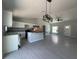 Open-concept living room and kitchen with gray tile flooring and modern lighting fixtures at 15419 Sw 65Th Terrace Rd, Ocala, FL 34473