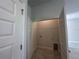A compact laundry room with tiled floors, utility connections and white wire shelving at 15833 Se 97Th Ter, Summerfield, FL 34491