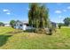 Well-maintained backyard showcases a pool with screened enclosure, complemented by mature trees and landscaping at 17915 Se 102Nd Ter, Summerfield, FL 34491