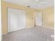 Bright bedroom features neutral carpet, ceiling fan, and a large closet with white bi-fold doors at 17915 Se 102Nd Ter, Summerfield, FL 34491