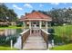 Picturesque gazebo on the pond offers a serene escape with its inviting wooden bridge and seating at 17915 Se 102Nd Ter, Summerfield, FL 34491