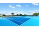 A vibrant blue tennis court complex with multiple courts ready for a match under a bright sky at 17915 Se 102Nd Ter, Summerfield, FL 34491