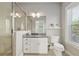 Bathroom featuring a granite vanity, white cabinets, a toilet, a window, and a glass-enclosed shower at 1906 Se 28Th Pl, Ocala, FL 34471
