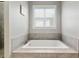Soaking tub with tile surround and a window at 1906 Se 28Th Pl, Ocala, FL 34471