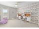 Bright bedroom featuring patterned wallpaper, a ceiling fan, and two study desks with white shelving at 1906 Se 28Th Pl, Ocala, FL 34471