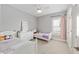 Cozy bedroom featuring two twin beds, a ceiling fan, and bright natural light from a window at 1906 Se 28Th Pl, Ocala, FL 34471