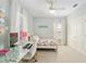 Bright bedroom with a light color scheme, a ceiling fan, a bed, a desk and a white closet door at 1906 Se 28Th Pl, Ocala, FL 34471