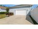 Attached two-car garage with a white door and concrete driveway, as well as a basketball hoop on the side at 1906 Se 28Th Pl, Ocala, FL 34471