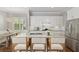Bright kitchen featuring white cabinetry, granite countertops, island seating, and stainless appliances at 1906 Se 28Th Pl, Ocala, FL 34471