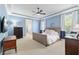 Blue main bedroom with a tray ceiling, carpeted floor, and natural light at 1906 Se 28Th Pl, Ocala, FL 34471