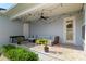 Covered patio with comfortable outdoor seating, ceiling fan, string lights, and lush landscaping at 1906 Se 28Th Pl, Ocala, FL 34471