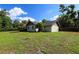 Exterior elevation showing a spacious backyard, mature trees, and fresh lawn at 2406 Se 40Th Street Rd, Ocala, FL 34480
