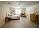 Bright bedroom featuring neutral walls, ceiling fan, wood-look flooring and accent rug at 2406 Se 40Th Street Rd, Ocala, FL 34480