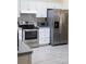 Bright kitchen showcasing stainless steel appliances, white cabinets, light gray countertops, and light wood-look floors at 2406 Se 40Th Street Rd, Ocala, FL 34480