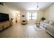 Spacious living room with light wood floors, modern furnishings, and large windows at 2406 Se 40Th Street Rd, Ocala, FL 34480