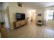 Open living area with light wood floors, TV, stylish console, and bright natural light at 2406 Se 40Th Street Rd, Ocala, FL 34480