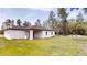 View of the back of a white single-story house with grass and a covered patio at 2438 Sw 165Th Street Rd, Ocala, FL 34473