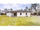 View of the back of a white single-story house with grass and trees at 2438 Sw 165Th Street Rd, Ocala, FL 34473