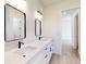 Modern bathroom featuring double sinks, quartz countertops, contemporary fixtures, and sleek mirrors at 2438 Sw 165Th Street Rd, Ocala, FL 34473