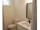 This bathroom features a toilet, sink, mirror, and neutral tones, creating a fresh and inviting space at 2438 Sw 165Th Street Rd, Ocala, FL 34473