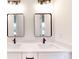 Bathroom featuring double sinks, quartz countertop, and dark framed mirrors with lights above at 2438 Sw 165Th Street Rd, Ocala, FL 34473