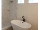 This bathroom offers a sleek and modern design with a large bathtub and walk-in shower with marble-style walls at 2438 Sw 165Th Street Rd, Ocala, FL 34473