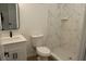 Bathroom featuring modern vanity, a toilet, and a tiled walk-in shower with marble accents at 2438 Sw 165Th Street Rd, Ocala, FL 34473