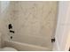 Bathroom showcasing a bathtub with stylish marbled tile surround and sleek black fixtures at 2438 Sw 165Th Street Rd, Ocala, FL 34473