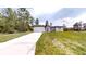 Single story house with a long driveway and modern elevation amid trees in front yard at 2438 Sw 165Th Street Rd, Ocala, FL 34473